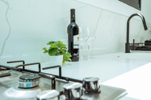 Una botella de vino en la parte superior de la encimera de la cocina en הרצל בוטיק מבית דומוס - Herzl Boutique Apartments by Domus, en Beer Sheva