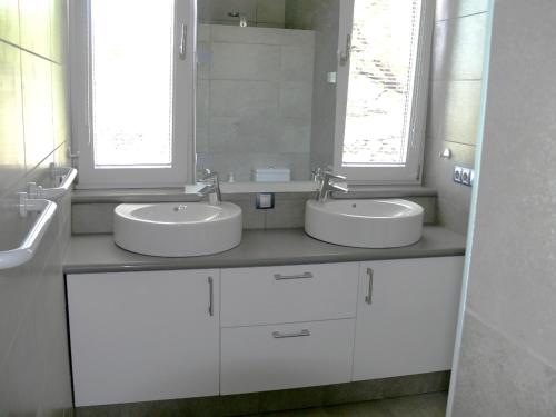 a white bathroom with two sinks and two windows at Villa Atlantico - beheizter Pool, Sauna in Tijarafe