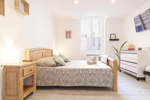 a white bedroom with a bed and a desk at M Suites - Gaillac Centre in Gaillac