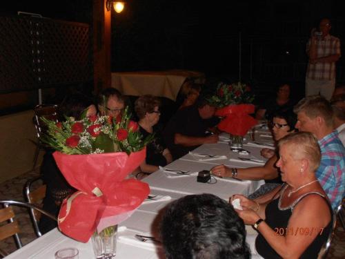 Nektar Beach Hotel في ستالوس: مجموعة من الناس يجلسون على طاولة مع الزهور