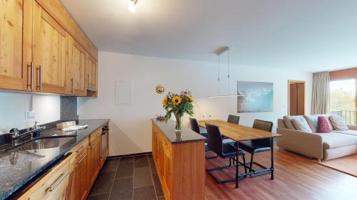a kitchen and living room with a table and a couch at Quadratscha 12 in Samedan