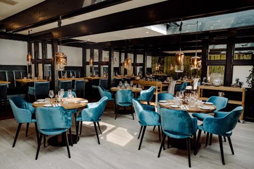 イゼンビュッテルにあるSeehotel am Tankumseeの青い椅子とテーブルが備わるレストラン
