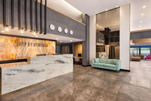 a lobby with a large marble counter and a blue couch at Tryp by Wyndham Istanbul Atasehir in Istanbul