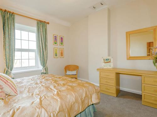una camera con letto, cassettiera e specchio di Jacks Cottage a Tinwell