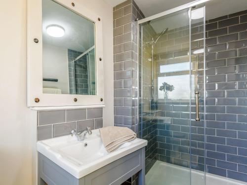 a bathroom with a sink and a glass shower at Jacks Cottage in Tinwell