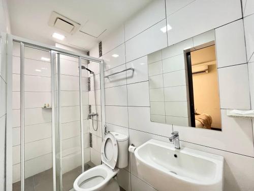 a bathroom with a toilet and a sink and a mirror at Swing & Pillows - KL Cheras Maluri in Kuala Lumpur