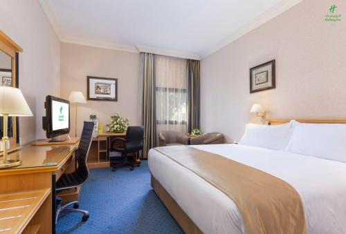 a hotel room with a bed and a desk and a computer at Holiday Inn Yanbu by IHG in Yanbu