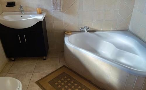 a bathroom with a white tub and a sink at Fish Eagle Villa in Hoedspruit
