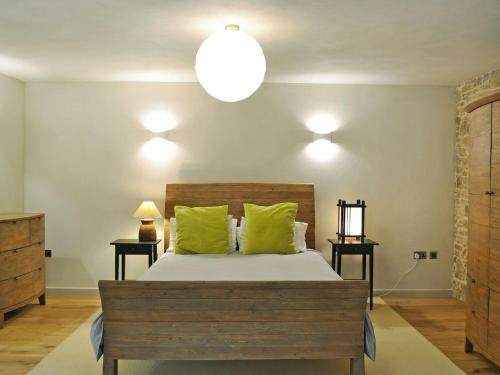 a bedroom with a bed with green pillows at Love Barn in Dartington
