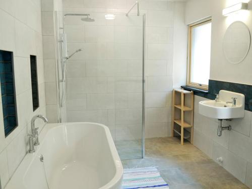 a white bathroom with a tub and a sink at Love Barn in Darlington