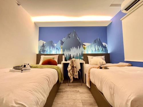 two beds in a room with a mountain mural on the wall at Swing & Pillows - KL Cheras Maluri in Kuala Lumpur