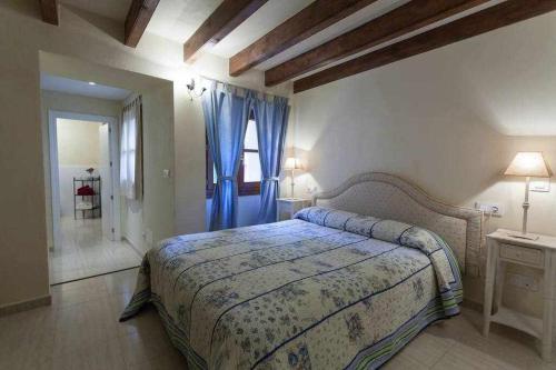 een slaapkamer met een bed en een raam met blauwe gordijnen bij Casa Fornalutx with Air Conditioning and a roof terrace with great views in Fornalutx