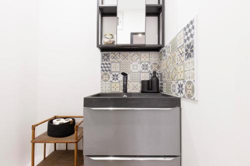 a kitchen with a refrigerator and a sink at M Suites - Gaillac Centre in Gaillac