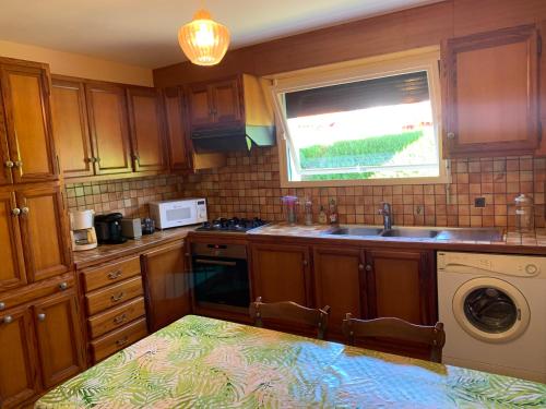 une cuisine avec un évier et une fenêtre dans l'établissement A louer appartement dans une maison, à Arcangues