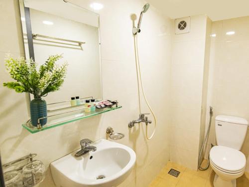 a bathroom with a sink and a toilet and a mirror at Madelise Max Hotel in Hanoi