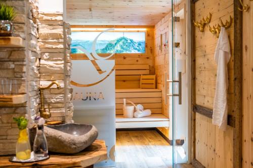 eine Sauna mit einer Badewanne und einem Fenster in der Unterkunft Hotel-Restaurant Burgblick in Dorfgastein