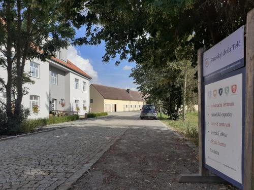 a street with a sign in front of a house at Penzion Panský dvůr Telč in Telč