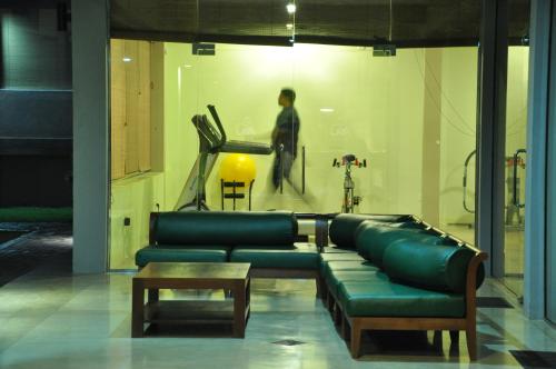 a living room with a couch and a man in a gym at Laya Safari Resorts & Spa in Yala