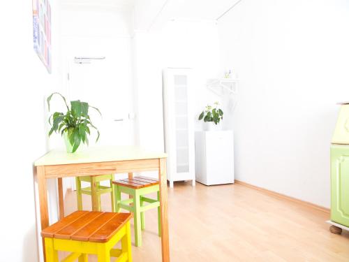 a kitchen with a table and chairs and a refrigerator at PM-Rooms in Munich