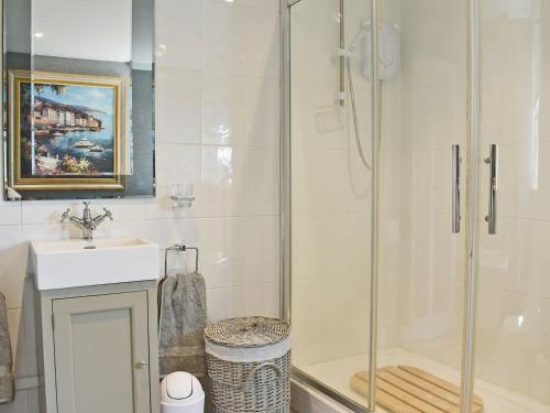 a bathroom with a shower and a sink at The Coach House in Peldon