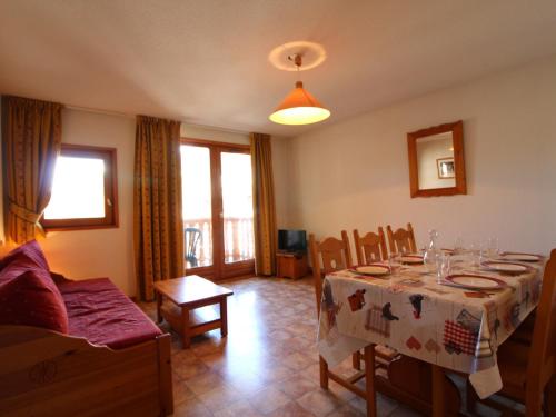 un salon avec une table, des chaises et un canapé dans l'établissement Appartement 6 pers, centre village, proche pistes, 52m², balcon, WIFI, casier à skis, draps inclus - FR-1-508-12, à Lanslevillard