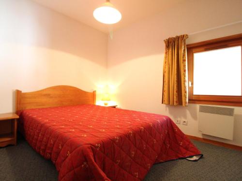 - une chambre avec un lit rouge et une fenêtre dans l'établissement Appartement 6 pers, centre village, proche pistes, 52m², balcon, WIFI, casier à skis, draps inclus - FR-1-508-12, à Lanslevillard