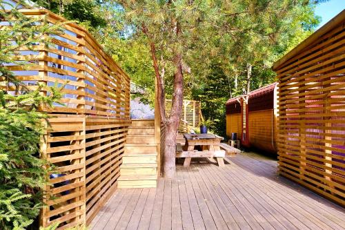 una terraza de madera con una valla de madera y una mesa de picnic en B&B KNARDAL SPA en Neset