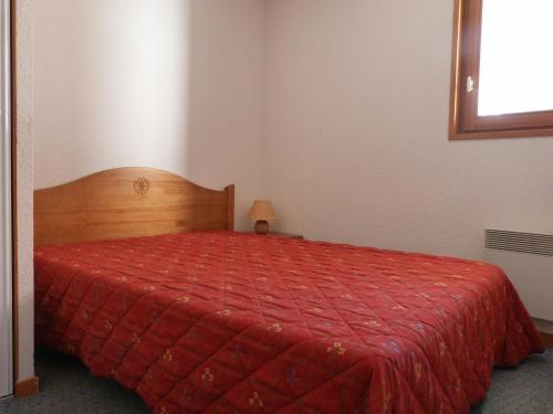 - une chambre avec un lit rouge et une couette rouge dans l'établissement Appartement pour 6 au centre de Lanslevillard, proche des pistes avec balcon et WIFI - FR-1-508-15, à Lanslevillard