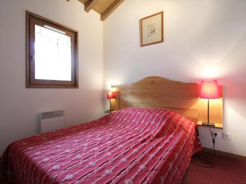 une chambre avec un lit avec une couette rouge et une fenêtre dans l'établissement Appartement Au Pied des Pistes pour 6 Personnes - Appartement Confortable à Val Cenis - FR-1-508-44, à Lanslevillard