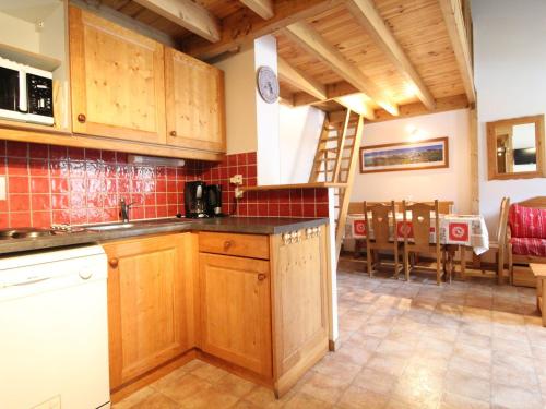 une cuisine avec des placards en bois et une salle à manger dans l'établissement Appartement Au Pied des Pistes pour 6 Personnes - Appartement Confortable à Val Cenis - FR-1-508-44, à Lanslevillard