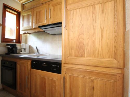 een keuken met houten kasten en een zwart apparaat bij Appartement Lanslevillard, 3 pièces, 6 personnes - FR-1-508-58 in Lanslevillard