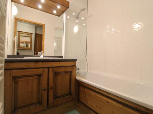 une salle de bain avec un lavabo, une baignoire et un miroir dans l'établissement Appart 6 pers avec piscine, skis, ascenseur à Lanslebourg - FR-1-508-93, à Lanslebourg-Mont-Cenis