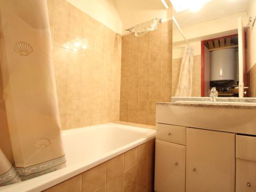 a bathroom with a tub and a sink at Appartement Lanslevillard, 2 pièces, 6 personnes - FR-1-508-112 in Lanslevillard