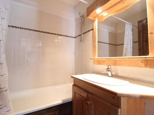 a bathroom with a sink and a tub and a mirror at Appartement Aussois, 3 pièces, 6 personnes - FR-1-508-36 in Aussois