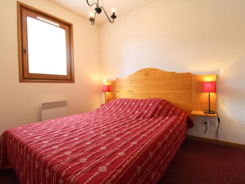 une chambre avec un lit avec une couette rouge et une fenêtre dans l'établissement Appartement Confort 4 Pers, Pied des Pistes, Parking Inclus, Lanslevillard-Val Cenis - FR-1-508-119, à Lanslevillard