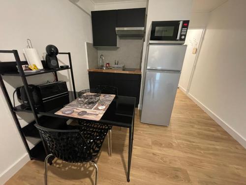 a small kitchen with a table and a refrigerator at Studio à Nice avec garage in Nice