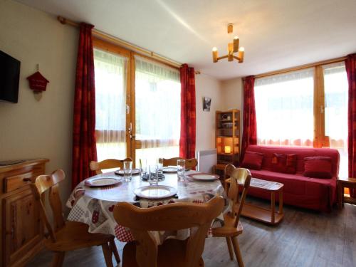 un salon avec une table et un canapé rouge dans l'établissement Appartement cosy 4 pers avec balcon et WIFI au pied des pistes - FR-1-508-123, à Lanslevillard