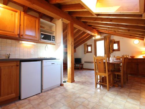 - une cuisine avec des appareils électroménagers blancs et une table dans l'établissement Appartement 6 pers à Lanslevillard-Val Cenis, proche pistes et commerces - FR-1-508-64, à Lanslevillard