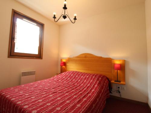 - une chambre avec un lit rouge et une fenêtre dans l'établissement Appartement spacieux pour 6 personnes, balcon exposé plein sud, pied des pistes à Val Cenis - FR-1-508-104, à Lanslevillard