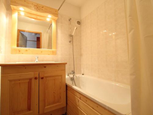 a bathroom with a tub and a sink and a mirror at Appartement Lanslevillard, 3 pièces, 6 personnes - FR-1-508-81 in Lanslevillard