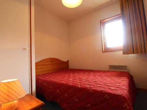 a bedroom with a red bed and a window at Appartement Lanslevillard, 3 pièces, 6 personnes - FR-1-508-81 in Lanslevillard