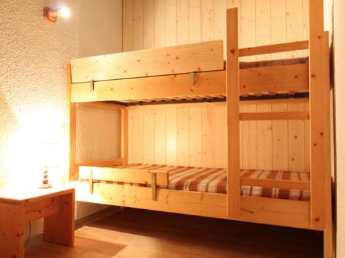 a wooden bunk bed in a room with a table at Appartement Lanslevillard, 1 pièce, 5 personnes - FR-1-508-82 in Lanslevillard