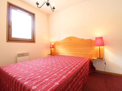 - une chambre avec un lit doté d'un couvre-lit rouge et d'une fenêtre dans l'établissement Appartement 6 personnes, Val-Cenis, au pied des pistes avec parking et WiFi - FR-1-508-113, à Lanslevillard