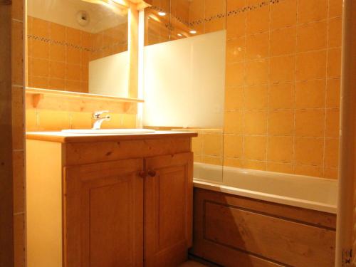 une salle de bain avec un lavabo, un miroir et une baignoire dans l'établissement Appartement 6 personnes, Val-Cenis, au pied des pistes avec parking et WiFi - FR-1-508-113, à Lanslevillard