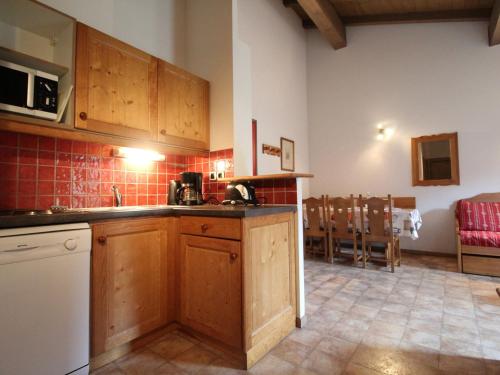 une cuisine avec des armoires en bois et un comptoir dans l'établissement Appartement cosy 6 pers à Val Cenis, au pied des pistes, proche commerces et services - FR-1-508-111, à Lanslevillard