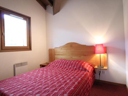 une chambre avec un lit avec une couette rouge et une fenêtre dans l'établissement Appartement cosy 6 pers à Val Cenis, au pied des pistes, proche commerces et services - FR-1-508-111, à Lanslevillard