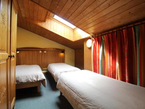a hotel room with two beds and red curtains at Appart cosy 6 pers, proche pistes, WiFi, parking, draps inclus - FR-1-508-117 in Lanslevillard