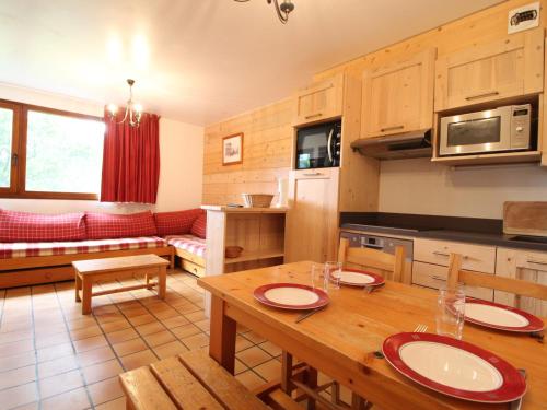 a kitchen and living room with a wooden table at Appartement cosy 5 pers. à Val Cenis Lanslevillard, proche télécabine et ESF, terrasse, wifi inclus - FR-1-508-131 in Lanslevillard