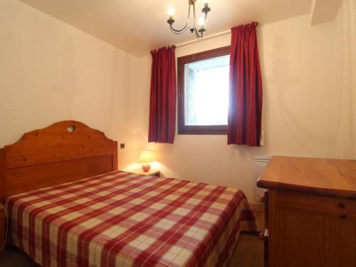 a bedroom with a bed and a window with red curtains at Appartement cosy 5 pers. à Val Cenis Lanslevillard, proche télécabine et ESF, terrasse, wifi inclus - FR-1-508-131 in Lanslevillard