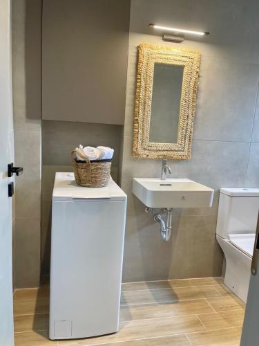 a bathroom with a sink and a basket on a counter at Campana’s Apartment in Argostoli